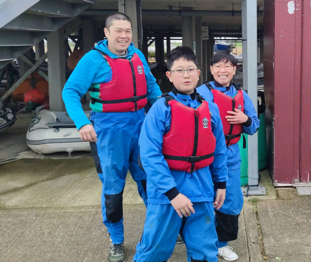 Family wearing club spray jackets and trousers and boyancy aids. 